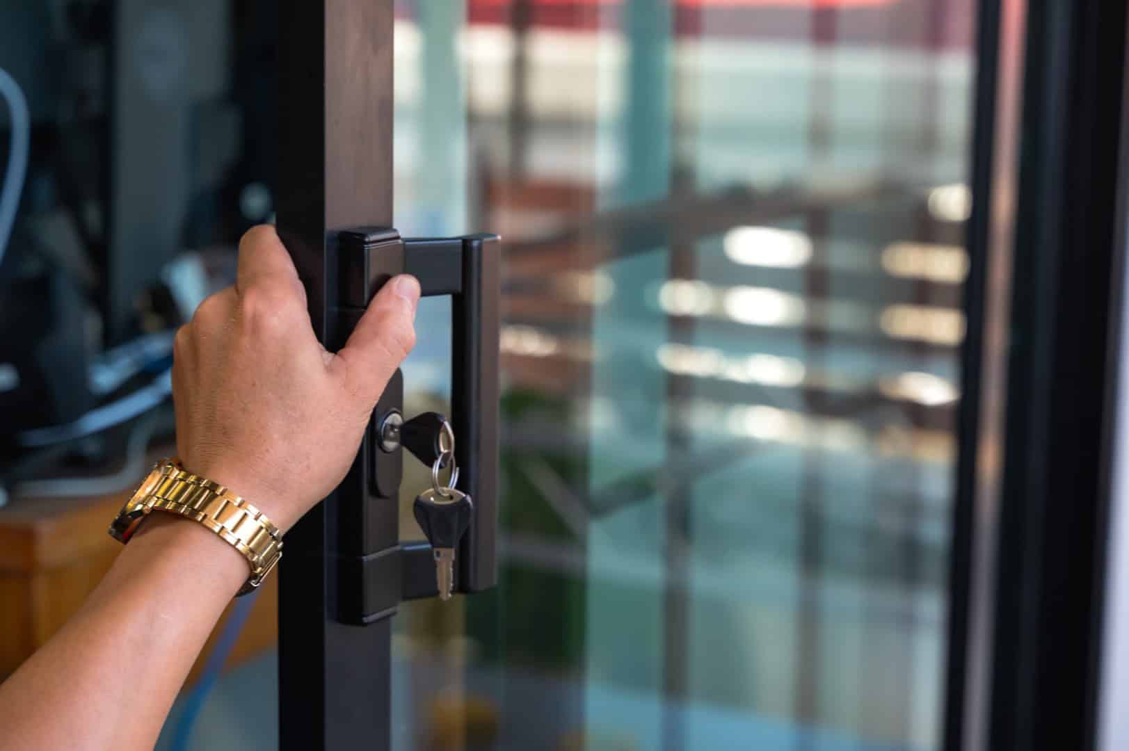 Close up locksmith installing door lock key on mirror door